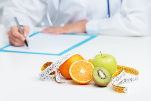 Nutritionist Doctor is writing a prescription. Focus on fruit ** Note: Shallow depth of field